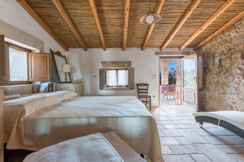 1 Schlafzimmer mit 2 Betten und einer Steinmauer in der Unterkunft Casolare Lu Potu in Sternatia
