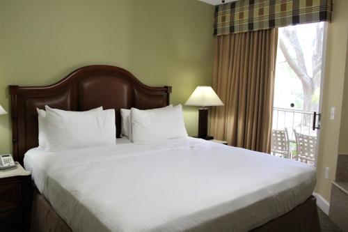 ein großes Bett in einem Hotelzimmer mit Fenster in der Unterkunft Cypress Pointe Resort in Orlando