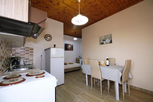 a kitchen and dining room with a table and a refrigerator at Fergani Apartments in Moúdhros