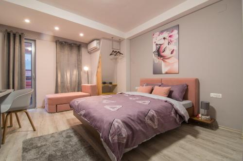a bedroom with a bed with a purple bedspread at Vanilla Boutique Hotel in Skopje