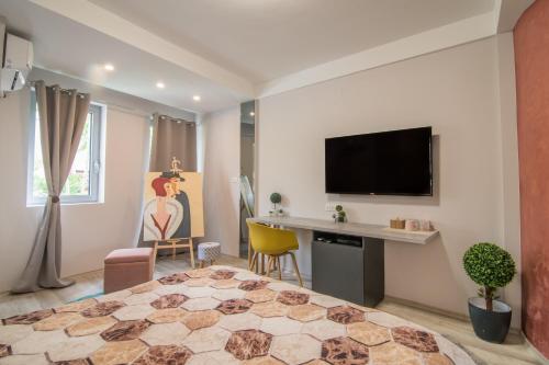 um quarto com uma cama, uma secretária e uma televisão em Vanilla Boutique Hotel em Skopje
