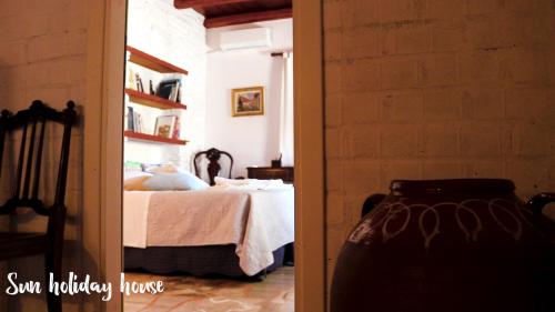 a bedroom with a bed and a room with a mirror at Sun Holiday House in Pisses
