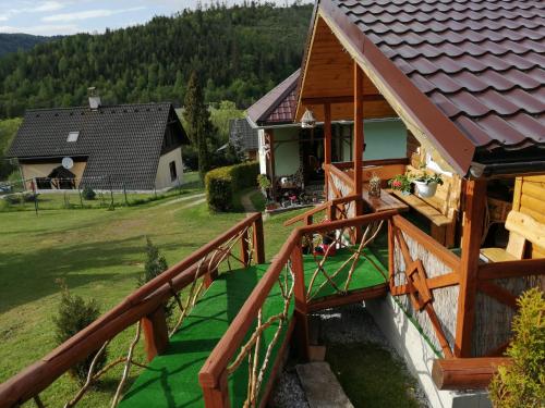 uma vista para uma casa com um corrimão de madeira em Ubytovanie Lesky em Mlynky 