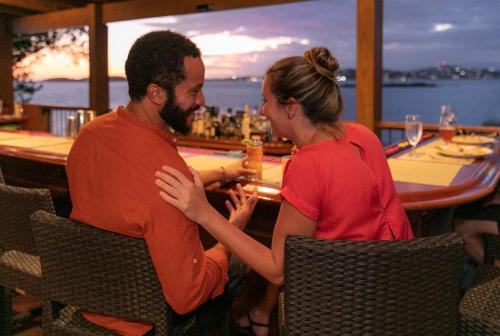 a man and a woman sitting at a bar at Gallows Point Resort in Saint John
