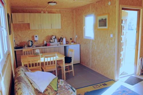 eine kleine Küche und ein Esszimmer mit einem Tisch in der Unterkunft Eurostruś - zoo, domki in Borzychy