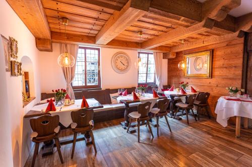 a restaurant with tables and chairs and a clock on the wall at Hotel & Restaurant Ritter Jörg in Sommerhausen