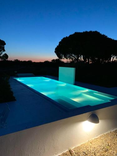 a swimming pool lit up at night at Casas do Sal in Alcácer do Sal