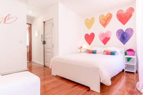 ein weißes Schlafzimmer mit Herzen an der Wand in der Unterkunft InLoveApartments - One Love, One Heart in Lissabon
