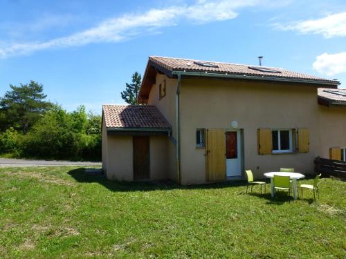 a house with a table and chairs in the yard at La longeagne in Aspres-sur-Buëch