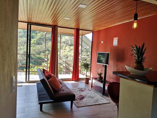 a living room with a couch and a large window at La Guayaba Monteverde in Monteverde Costa Rica