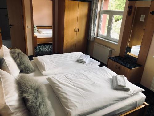 a bedroom with two beds with white sheets and furry pillows at Stiefelburg Der Berghof in Nauendorf