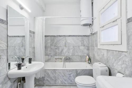 a white bathroom with a sink and a tub and a toilet at 4BDR Amazing Spacious full Apt in Plaka (and Netflix) in Athens