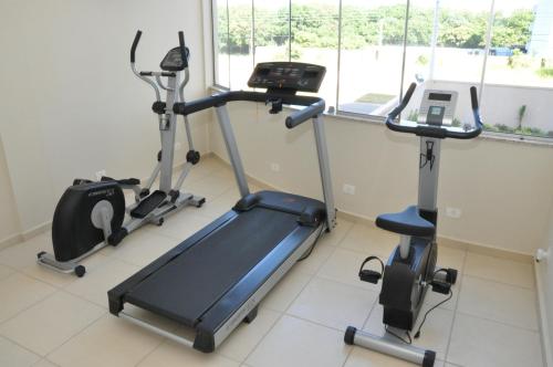 a gym with two exercise bikes and a treadmill at Lotus Hotel - à 6 km do Santuário de Aparecida-SP in Guaratinguetá