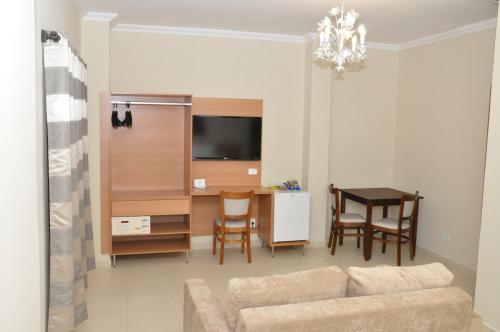 a living room with a couch and a table at Lotus Hotel - à 6 km do Santuário de Aparecida-SP in Guaratinguetá