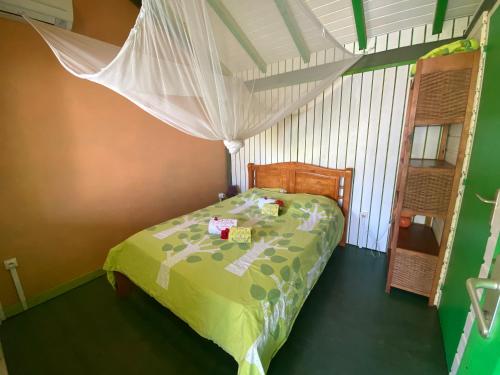 a bedroom with a bed with a green comforter at Gites titanse, Le jardin d'Antonin in Cadet