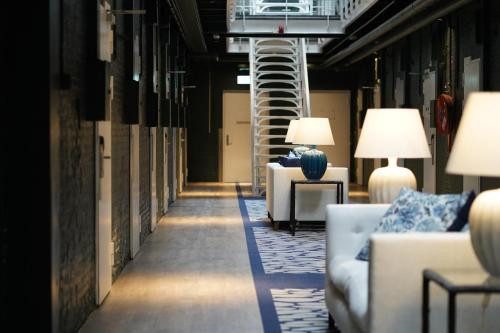 a hallway with couches and chairs in a building at Fletcher Hotel-Restaurant De Oude Gevangenis-Alkmaar in Alkmaar