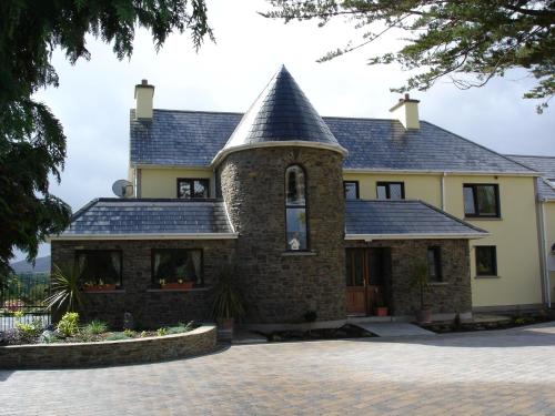 a large stone house with a turret at AbbeyCourt Kenmare Kerry in Kenmare