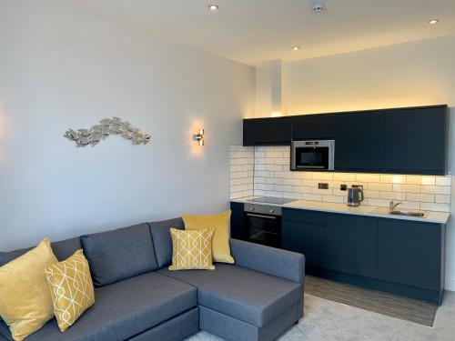 sala de estar con sofá azul y cocina en The Marlborough Sea View Holiday Apartments en Scarborough