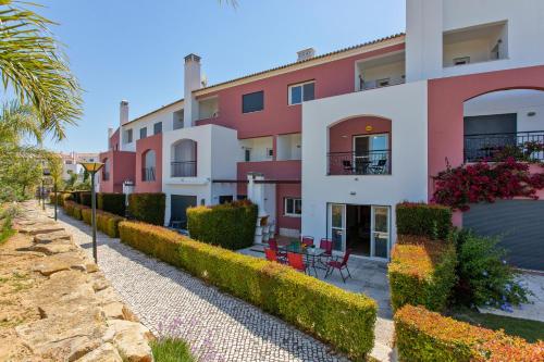 a building with a row of plants next to a street at Casa Joana at Opomar by Cara Rentals in Cabanas de Tavira