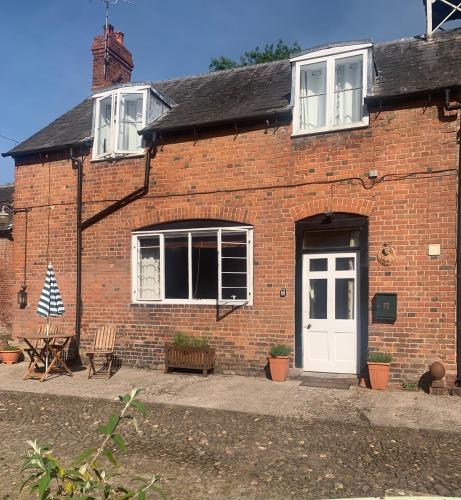 a red brick house with a white door at Lavender Cottage in Hereford