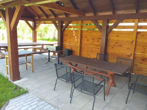 a wooden picnic table and chairs on a patio at Pensjonat pod Kasztanem in Ełk