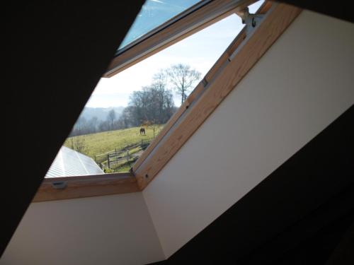 - une fenêtre dans une chambre avec vue sur un champ dans l'établissement Chez Juliette Maison Gite Hôtel, à Rontignon