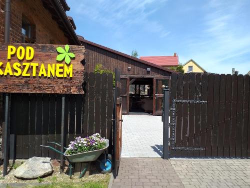 a wooden fence with a sign for a pool restaurant at Pensjonat pod Kasztanem in Ełk