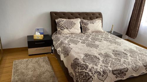 a bed with a black and white comforter and pillows at Arician full service in Ocna Şugatag