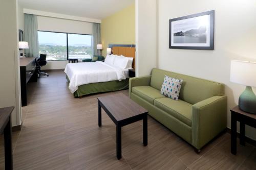a hotel room with a bed and a couch and a table at Holiday Inn Tampico-Altamira, an IHG Hotel in Tampico