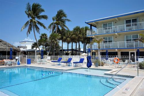 una piscina con sillas azules y un hotel en Glunz Ocean Beach Hotel and Resort, en Marathon