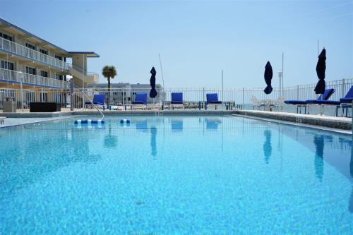 a large swimming pool with blue chairs in a building at Glunz Ocean Beach Hotel and Resort in Marathon