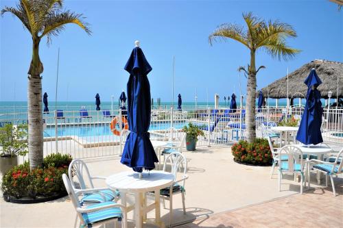 a group of tables and chairs with the ocean in the background at Glunz Ocean Beach Hotel and Resort in Marathon