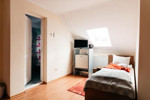 a small bedroom with a bed and a mirror at Pension Rose-Trandafirul in Borsec