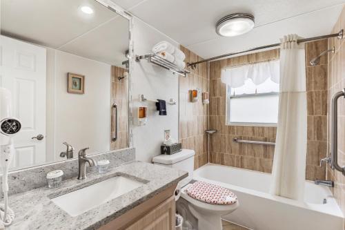 a bathroom with a tub and a sink and a toilet at Plaza Beach Hotel - Beachfront Resort in St Pete Beach