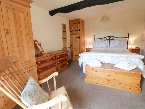 a bedroom with a bed and a wooden chair at Wigwell Barn in Alderwasley