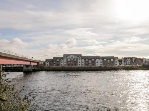 a bridge over a river with buildings in the background at Riverview Apartment in Inverness
