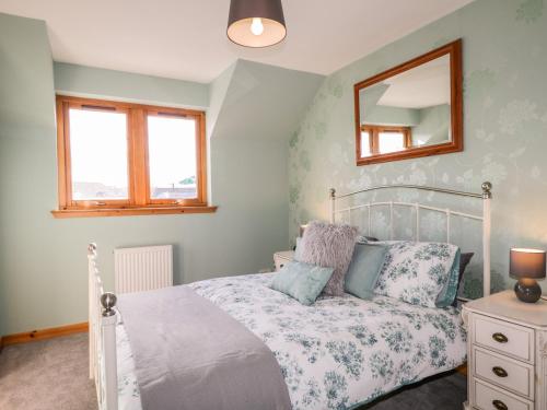 a bedroom with a bed and a mirror on the wall at Riverview Apartment in Inverness
