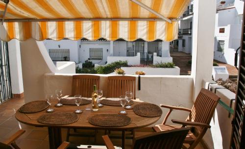 una mesa de madera con copas de vino en el balcón en Costa del Sol, Puerto de la Duquesa, en Castillo de Sabinillas