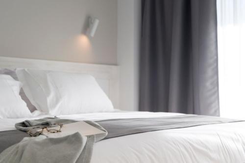 
a bed with white sheets and a white comforter at Mediterraneo Sitges in Sitges
