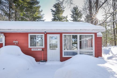 ein kleines rotes Haus mit Schnee auf dem Boden in der Unterkunft Roadside Duplex in Arbor Vitae