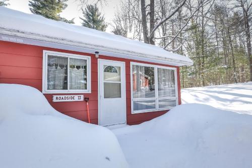 ein rotes Haus mit einem Fenster und Schnee umhüllt in der Unterkunft Roadside Duplex in Arbor Vitae