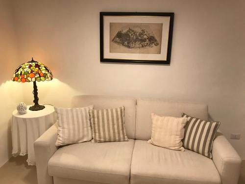 a white couch in a living room with a lamp at La Casa di Bacco B&b in Alezio