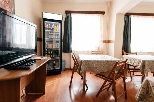 a living room with a tv and a table and chairs at Pension Rose-Trandafirul in Borsec