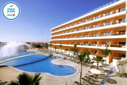 um hotel com piscina em frente a um edifício em Hotel Apartamento Balaia Atlantico em Albufeira