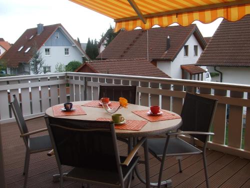 een tafel op een balkon met 2 kopjes en stoelen bij Ferienwohnung Rheintal in Kappel-Grafenhausen
