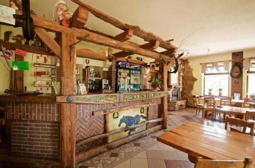 restauracja z drewnianym blatem oraz stołem i stołami w obiekcie Tawerna-Stawiska w mieście Garbatka-Letnisko