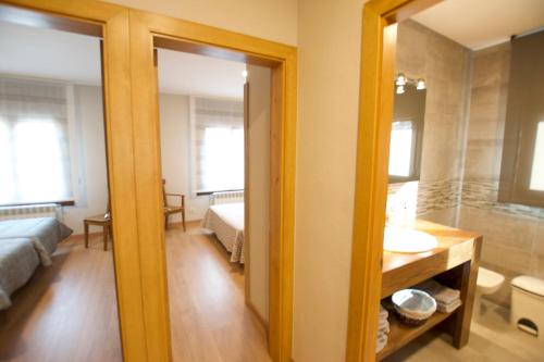 1 dormitorio y baño con lavabo y espejo. en Cal Ventura, en Prats i Sansor