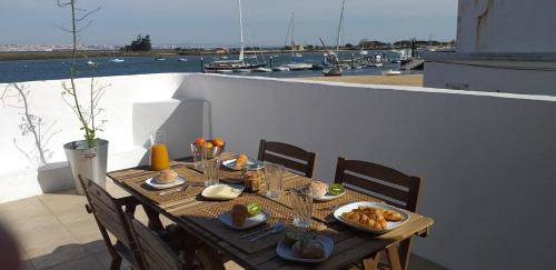 a wooden table with food on top of a balcony at Casa do Rio - Riverside House in Seixal