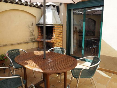 Une table et des chaises en bois sont disponibles sur la terrasse. dans l'établissement Casa De Nohales, à Nohales