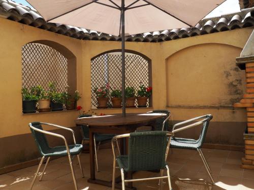 un patio con mesa, sillas y sombrilla en Casa De Nohales, en Nohales